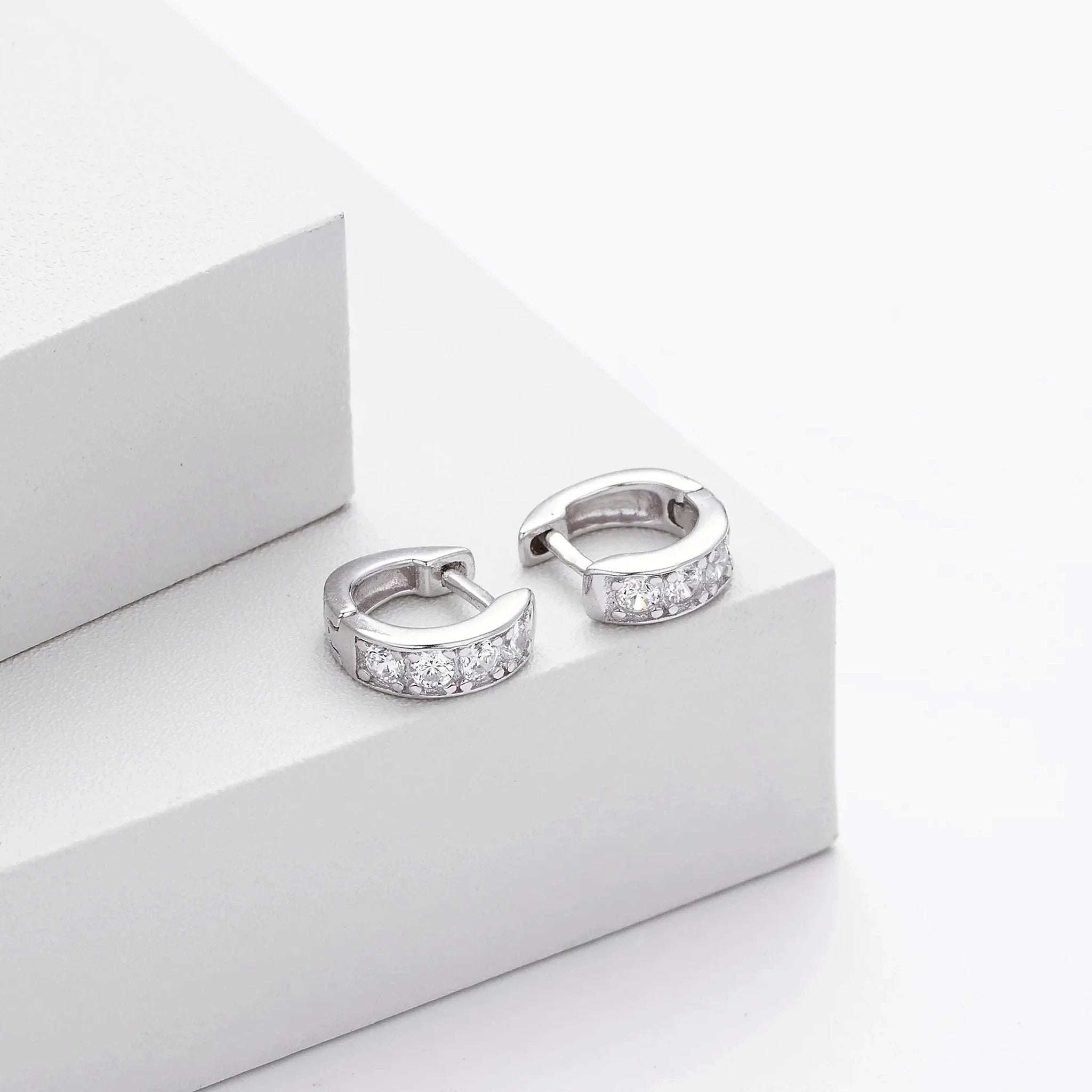 Ciela Beaded Pave Huggie Earrings in an editorial styling view