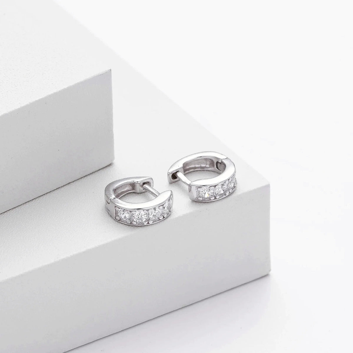 Ciela Beaded Pave Huggie Earrings in an editorial styling view