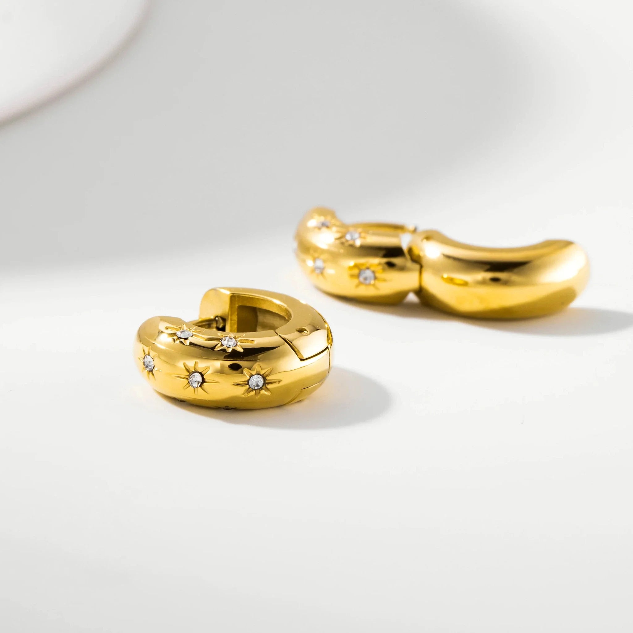 Nova Starburst Huggie Earrings worn in an ear styling look